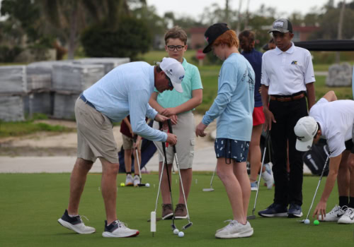 Man showing boys how to golf