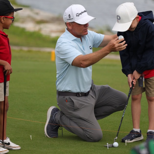 Man teaching boy to putt