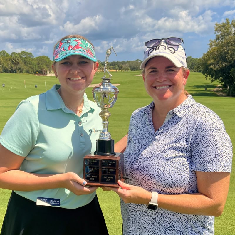 Two people holding trophy