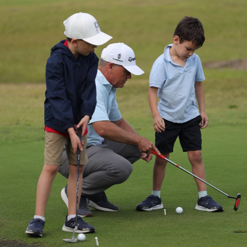 Young Boys Learning to Putt a Golf Ball